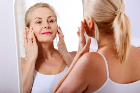 photo of mature woman looking in mirror